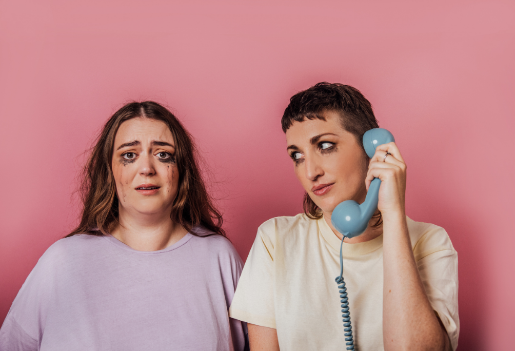 Two people on a pink background looking like they're crying.jpg